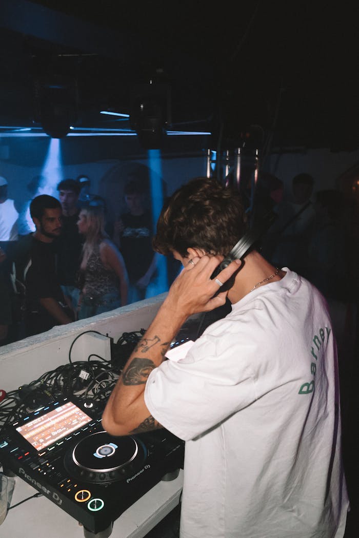 Home DJ performing live in a vibrant nightclub setting with a lively crowd.